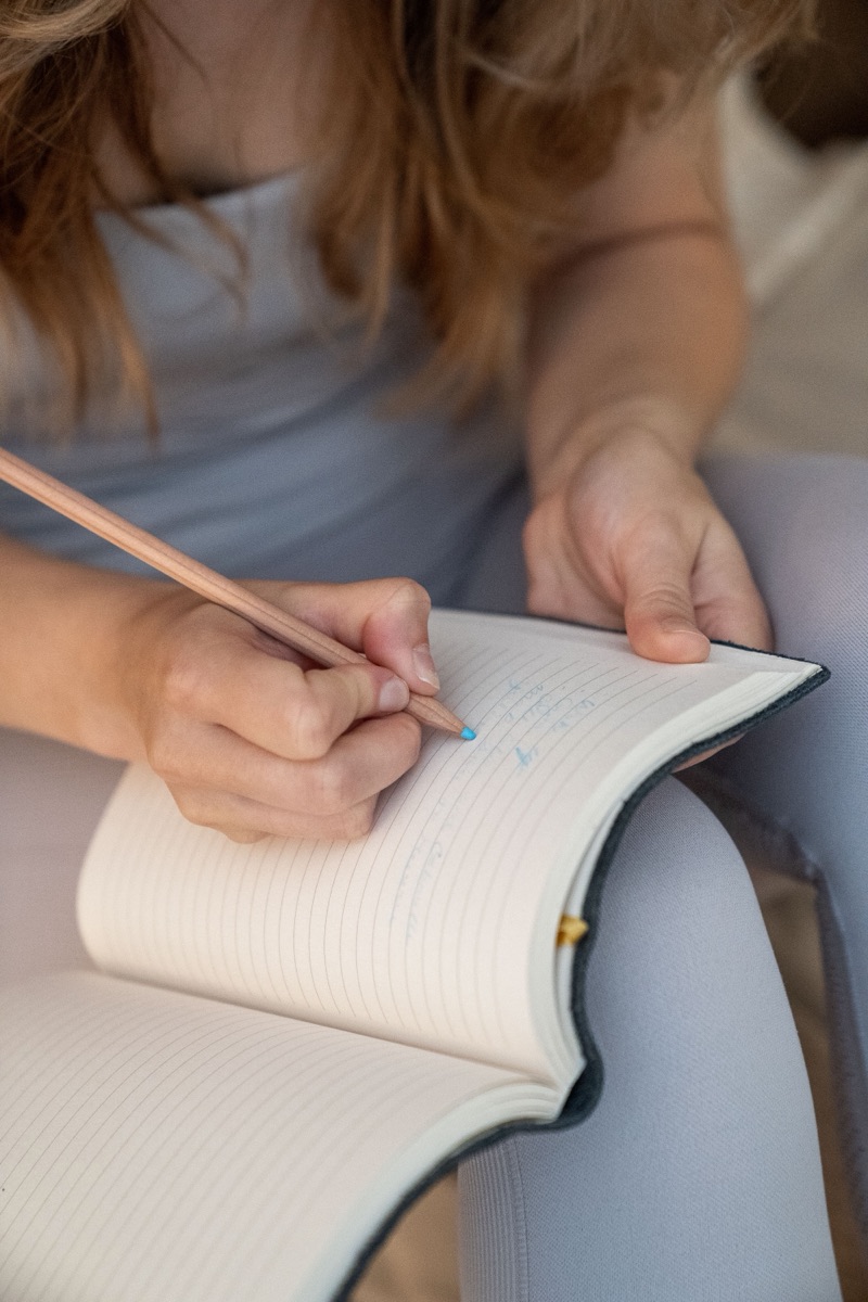 Close-up of hands writing in a journal