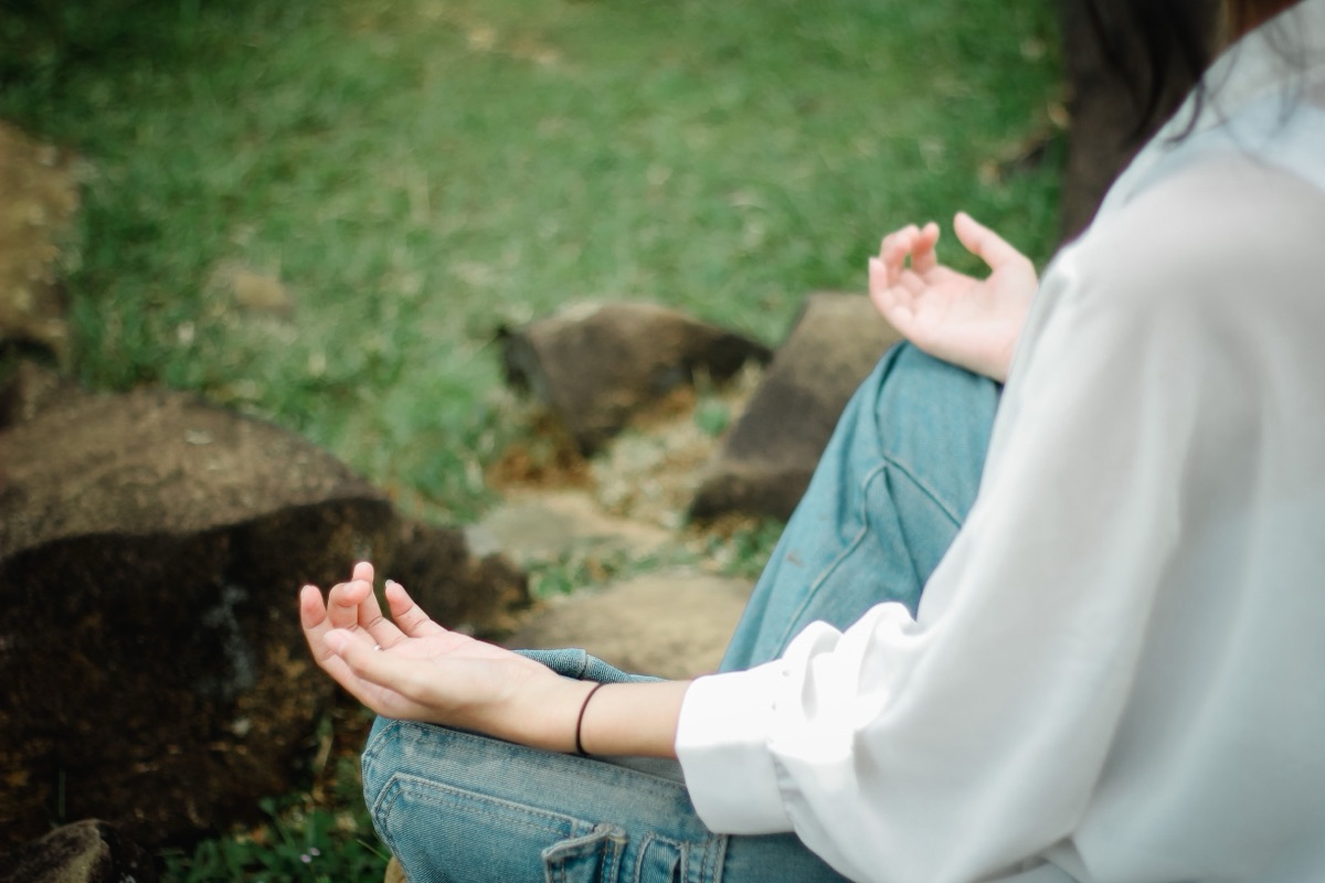 Close-up of hands in a meditation pose outdoors
